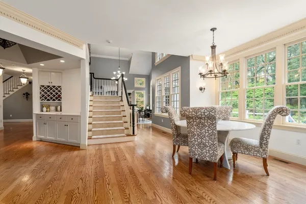 a view of a dining room and livingroom with furniture wooden floor a chandelier