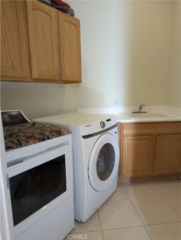 a utility room with sink dryer and washer