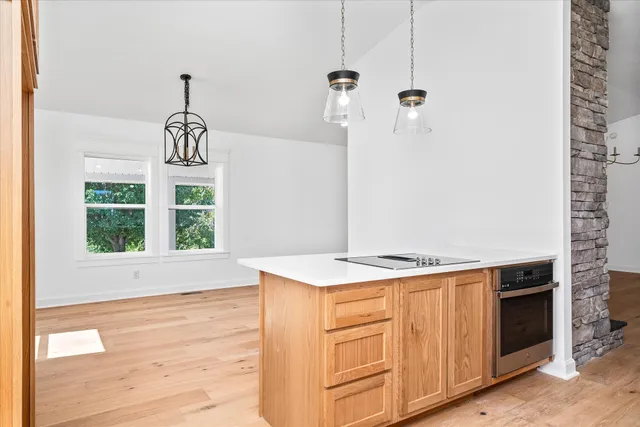 a kitchen with a stove and a wooden floor