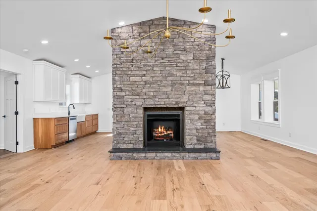 a living room with a fireplace and chandelier