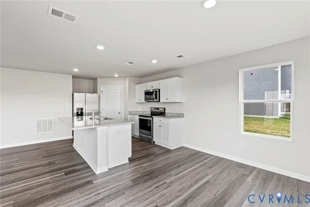 a kitchen with a refrigerator and a stove top oven