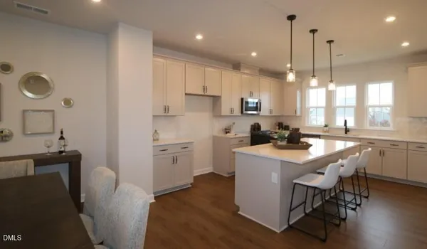 a kitchen with a sink a stove a refrigerator a dining table and chairs