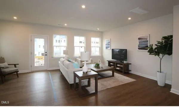 a living room with furniture a flat screen tv and a large window