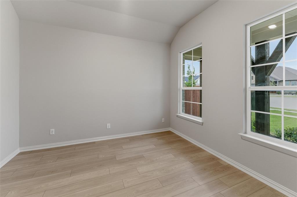 1237 Frio Drive Springtown, TX 76082 - Photo 6 of 25 Room featuring light gray walls, wood-finish flooring, white baseboards, and two windows with white grilles