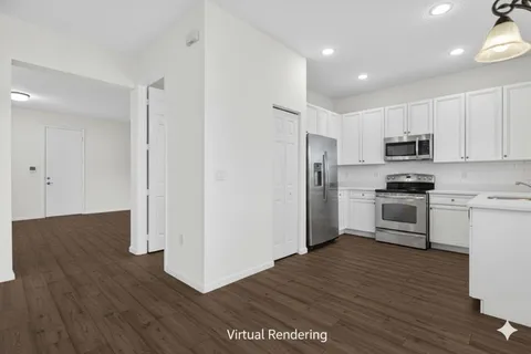 a kitchen with granite countertop a refrigerator and a stove top oven