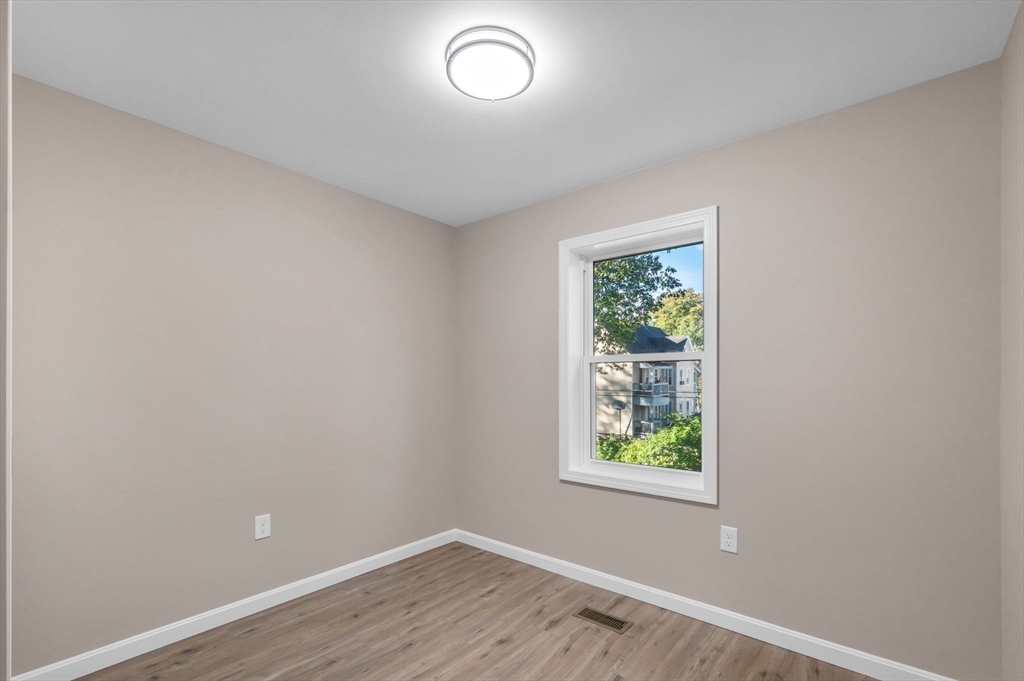121-123 Putnam Circle Springfield, MA 01104 - Photo 12 of 18 an empty room with wooden floor and windows