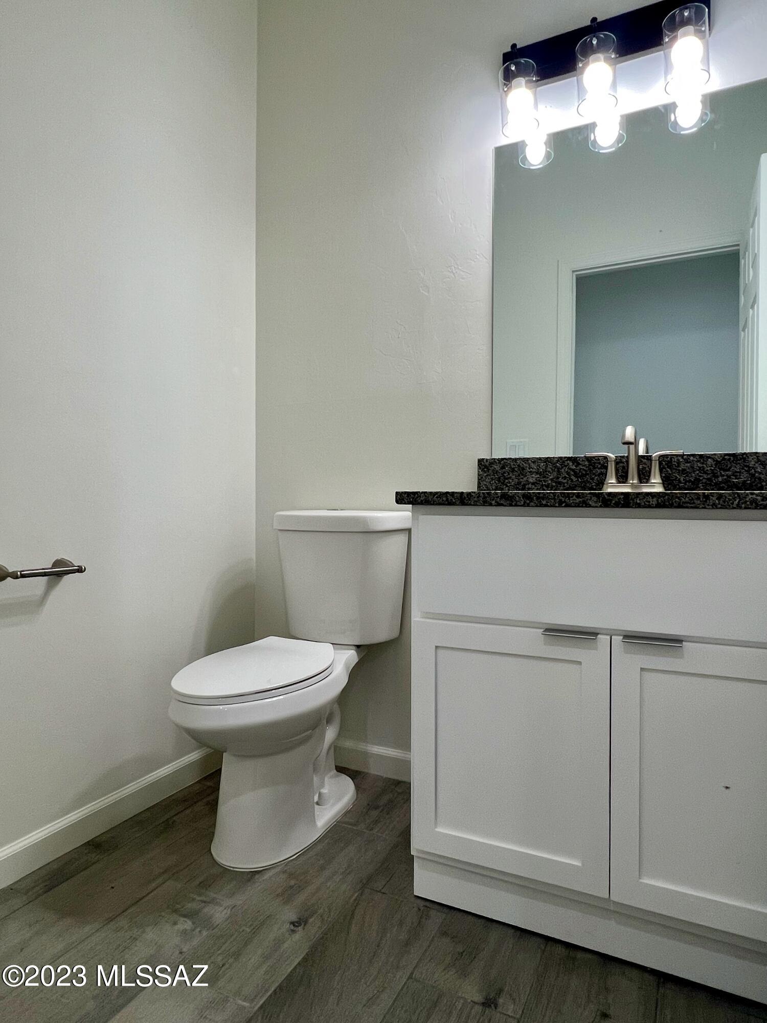 353 Dock Street Rio Rico, AZ 85648 - Photo 12 of 50 a bathroom with a granite countertop toilet a sink and a mirror