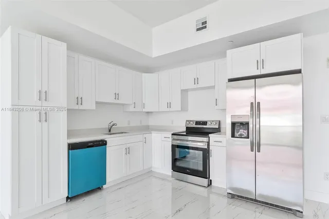 a kitchen with cabinets stainless steel appliances and a counter space