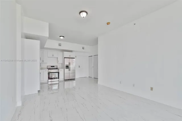 a view of a kitchen with refrigerator and chairs