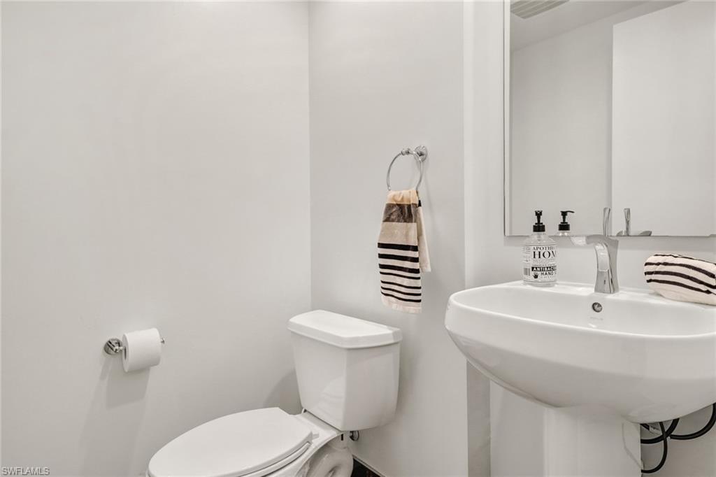 3000 Oasis Grand Boulevard, Unit 606 Fort Myers, FL 33916 - Photo 13 of 47 a bathroom with a sink a toilet and a mirror