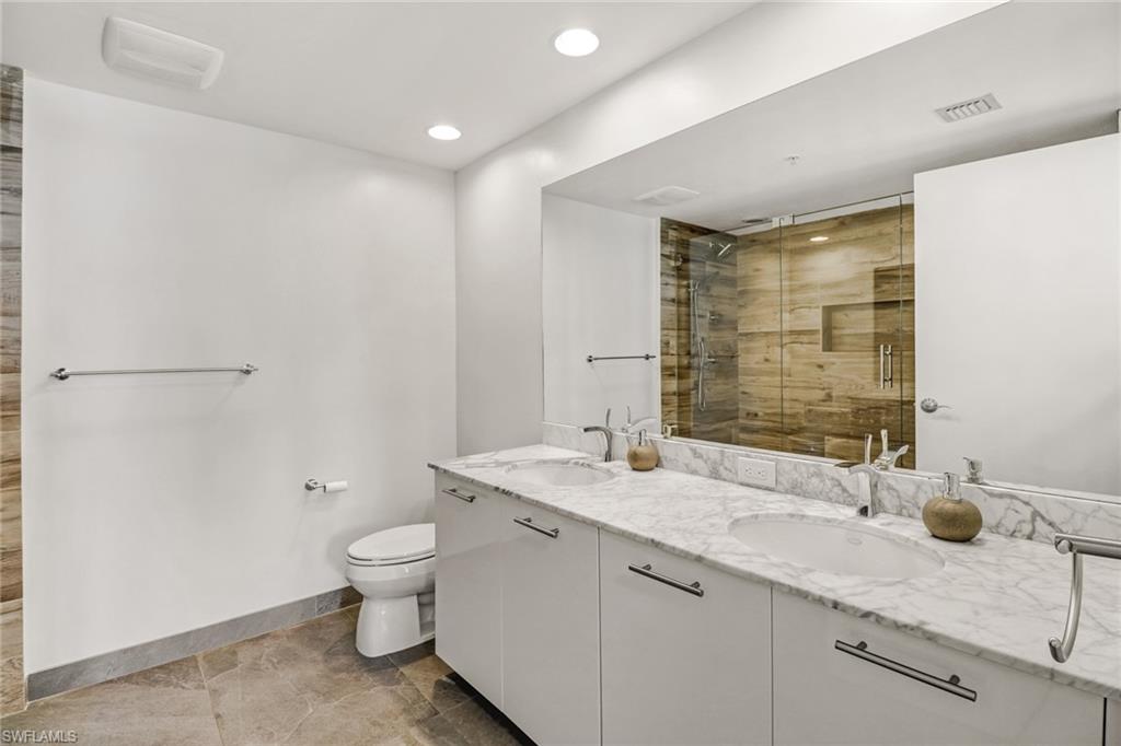 3000 Oasis Grand Boulevard, Unit 606 Fort Myers, FL 33916 - Photo 20 of 47 a bathroom with a granite countertop sink a toilet and shower