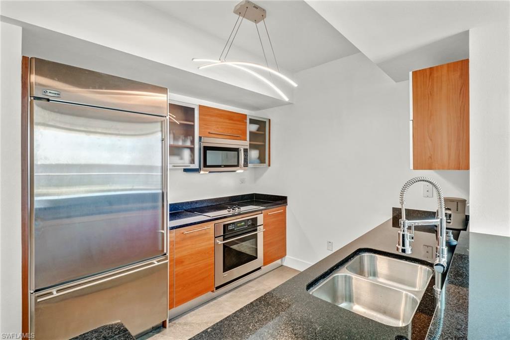 3000 Oasis Grand Boulevard, Unit 606 Fort Myers, FL 33916 - Photo 6 of 47 a kitchen with stainless steel appliances granite countertop a sink and a refrigerator