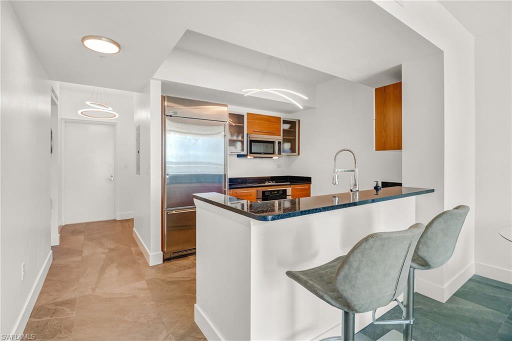 3000 Oasis Grand Boulevard, Unit 606 Fort Myers, FL 33916 - Photo 10 of 47 a kitchen that has a table and chair in it