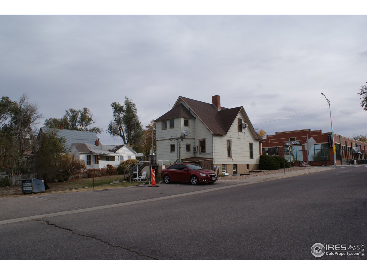 175 South Main Street Brighton, CO 80601 - Photo 3 of 13 a front view of a house with a garden and parking space