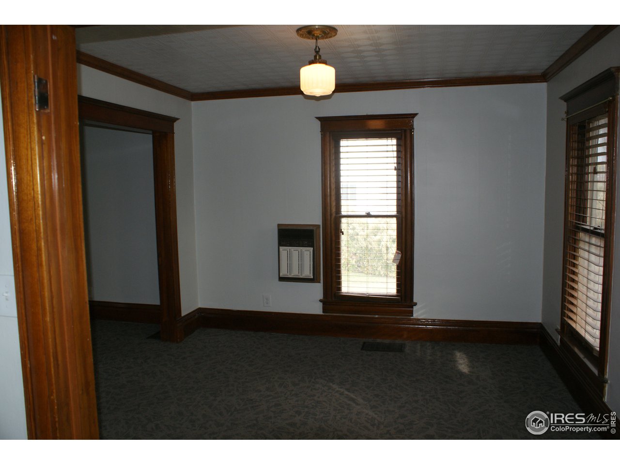 175 South Main Street Brighton, CO 80601 - Photo 5 of 13 a view of an empty room with wooden floor and window