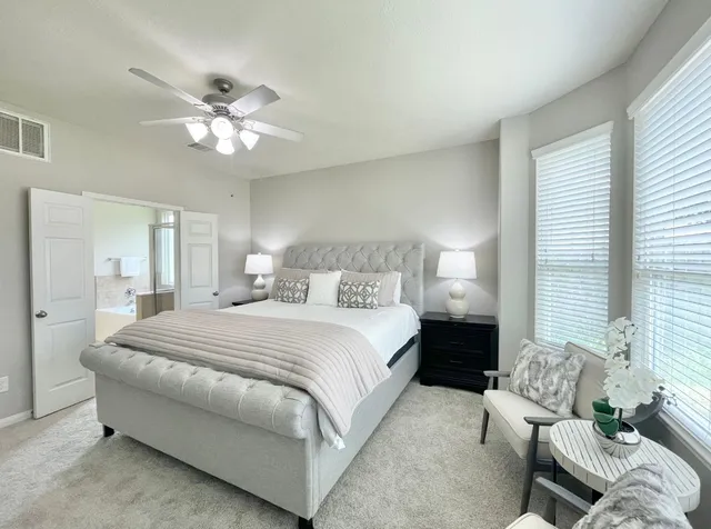 a spacious bedroom with a bed and a chandelier