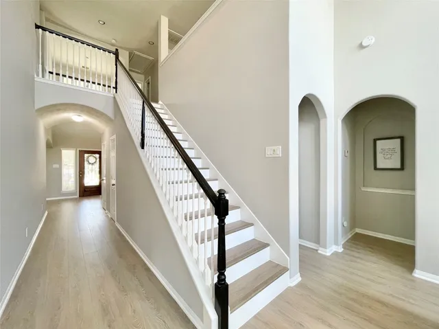 a view of staircase with railing and a chandelier