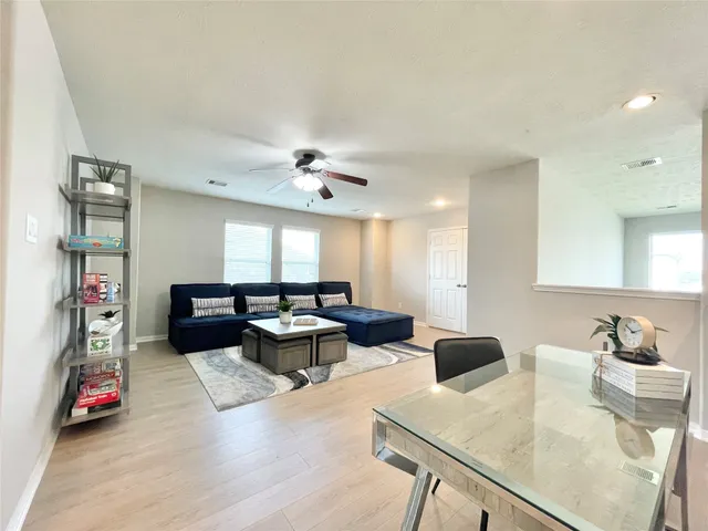 a living room with furniture and a wooden floor