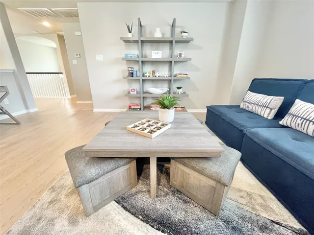 a living room with furniture and a wooden floor