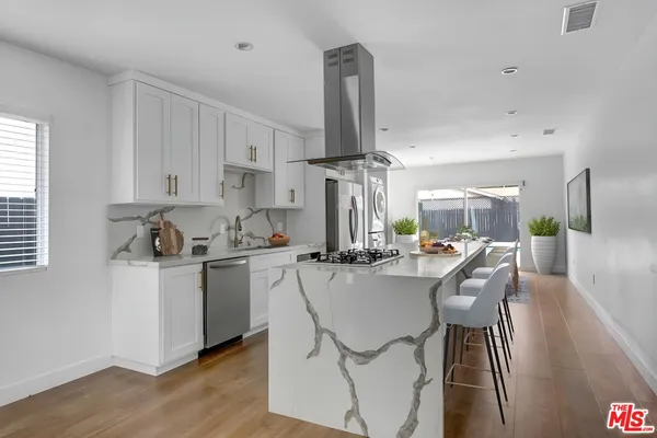 a kitchen with stainless steel appliances a table and chairs