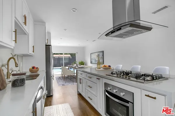 a kitchen with a stove a sink and cabinets