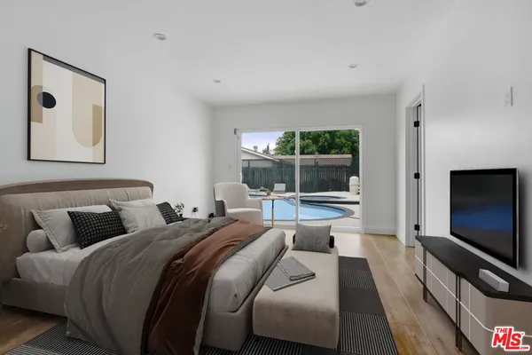 a bedroom with bed and a flat screen tv