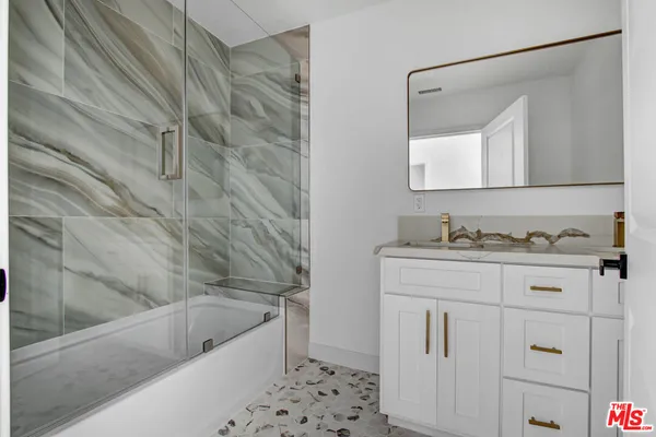 a bathroom with a granite countertop sink a toilet and bathtub