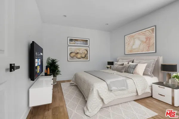 a bedroom with a bed and a flat screen tv