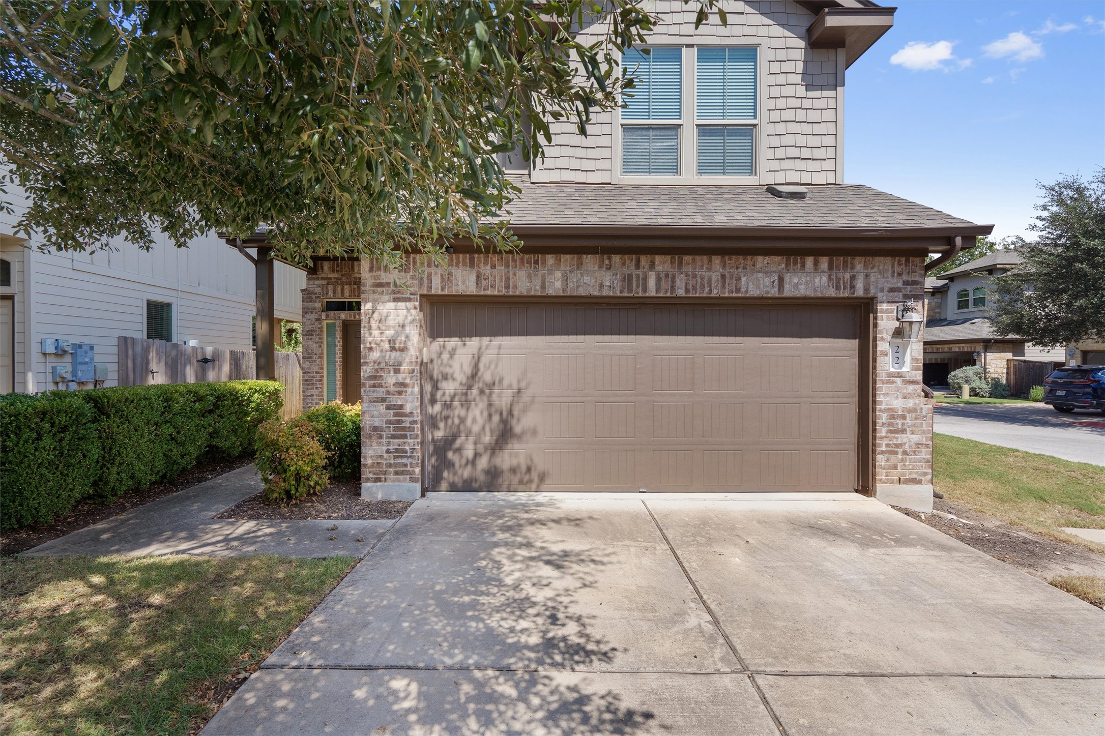 7709 Menchaca Road, Unit 22 Austin, TX 78745 - Photo 2 of 35 a front view of a house with a garden and garage