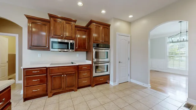 a spacious bedroom with a bed a chandelier and a flat screen television