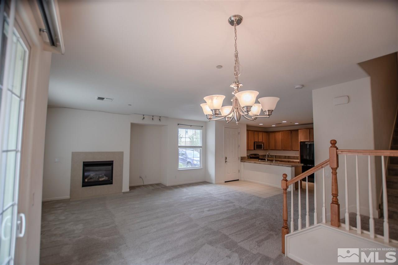 1900 Wind Ranch Road, Unit RENO Reno, NV 89521 - Photo 11 of 25 a view of a livingroom with a fireplace a chandelier and wooden floor