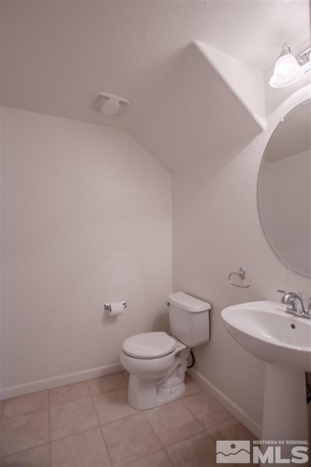 1900 Wind Ranch Road, Unit RENO Reno, NV 89521 - Photo 13 of 25 a white toilet sitting next to a bathroom sink and a mirror