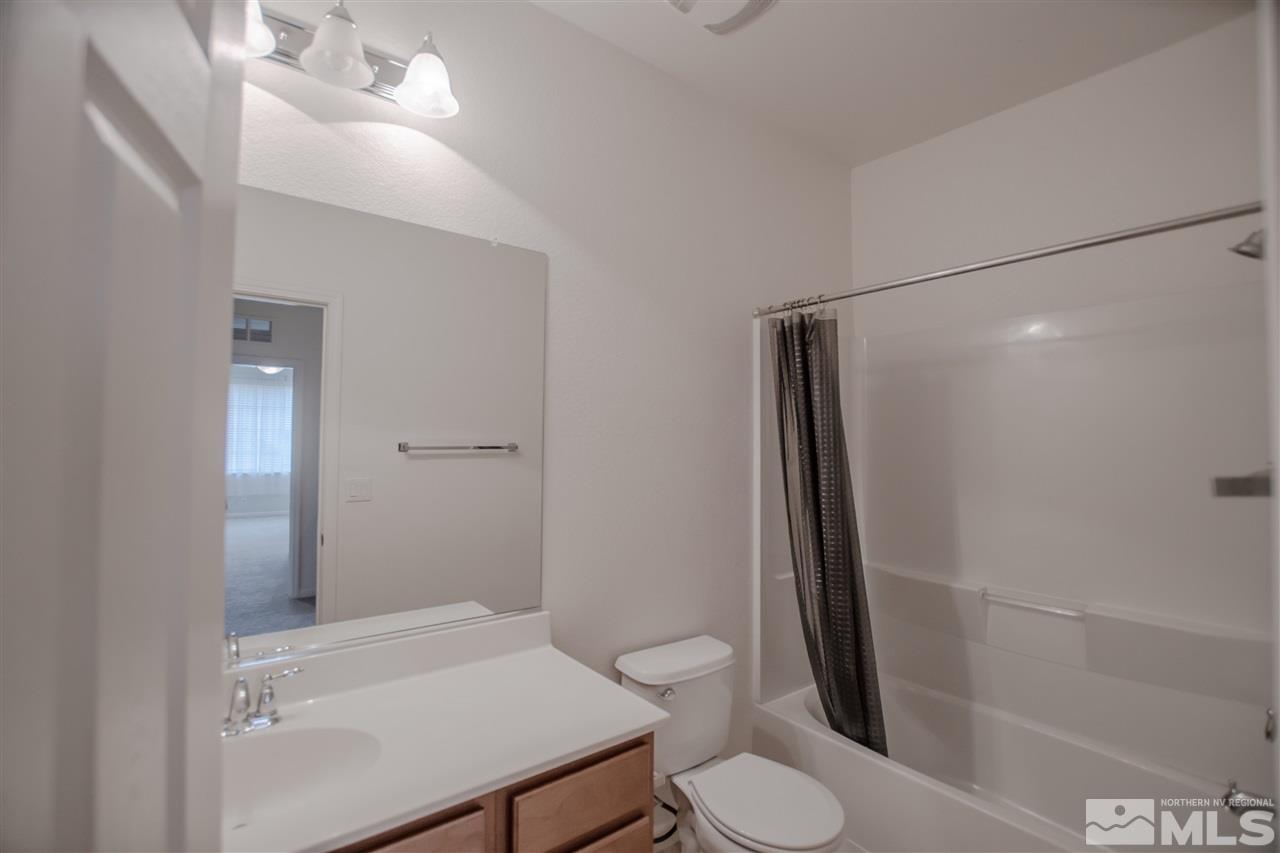 1900 Wind Ranch Road, Unit RENO Reno, NV 89521 - Photo 20 of 25 a bathroom with a sink a toilet and shower