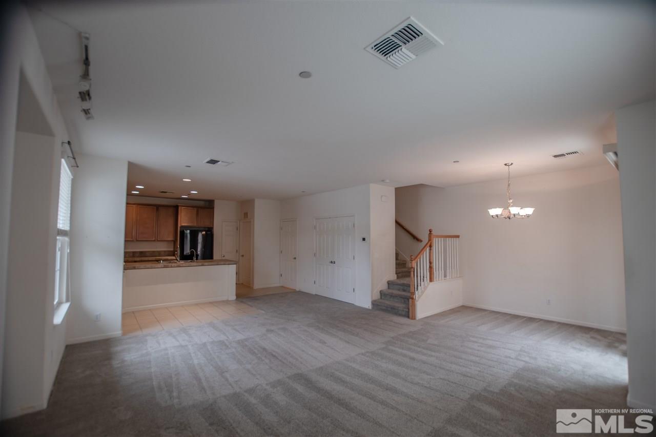 1900 Wind Ranch Road, Unit RENO Reno, NV 89521 - Photo 5 of 25 an empty room with wooden floor and windows
