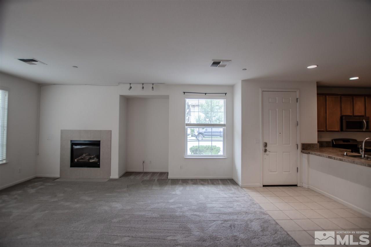 1900 Wind Ranch Road, Unit RENO Reno, NV 89521 - Photo 6 of 25 an empty room with a fireplace and window