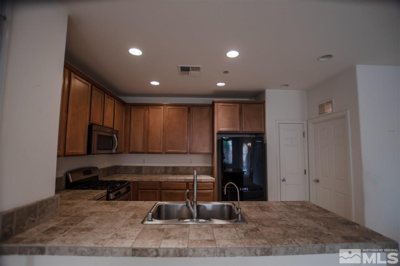 1900 Wind Ranch Road, Unit RENO Reno, NV 89521 - Photo 9 of 25 a kitchen with a refrigerator and a stove top oven