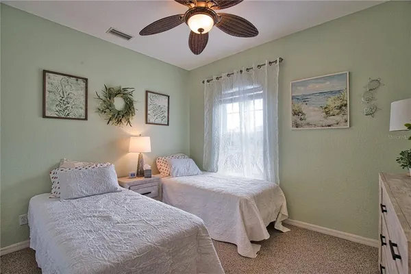 a bedroom with two bed and a window