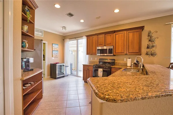a kitchen with kitchen island granite countertop a sink counter top space appliances and cabinets