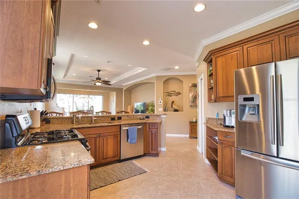 a kitchen with stainless steel appliances granite countertop sink stove top oven and refrigerator