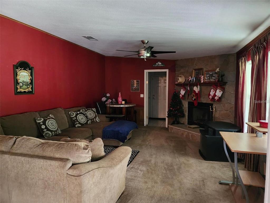 13921 Pine Meadow Road Kathleen, FL 33849 - Photo 9 of 25 a living room with furniture and a flat screen tv