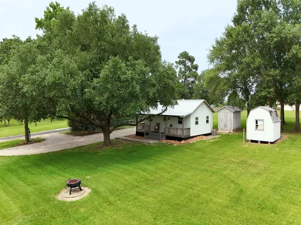 a front view of a house with a yard and trees