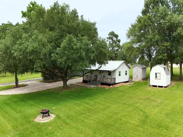 a front view of a house with a yard and trees