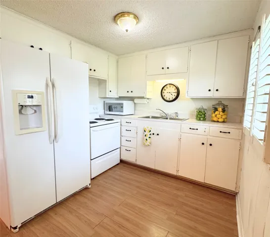 a kitchen with cabinets stainless steel appliances and wooden floor
