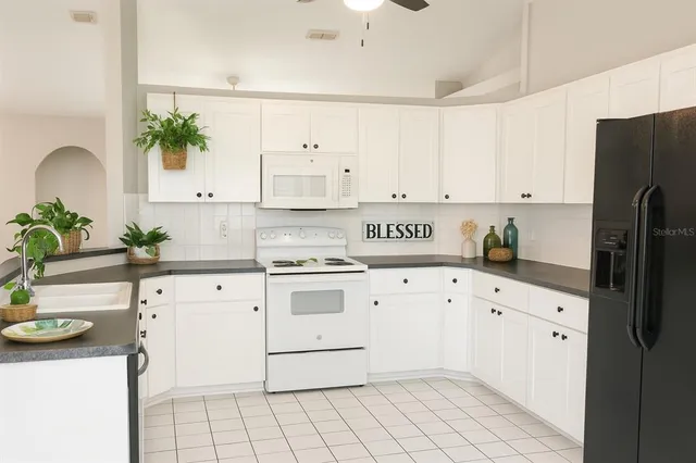 a kitchen with granite countertop white cabinets and white appliances