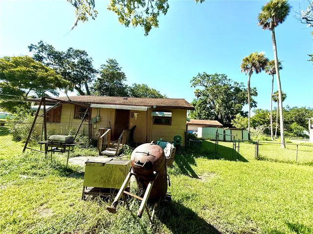 a view of a house with backyard and sitting area