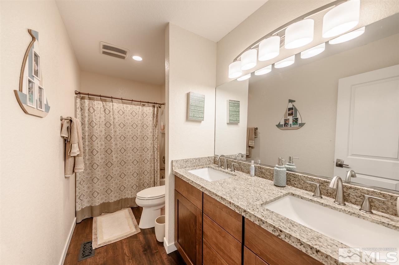 1844 Quail Run Road Reno, NV 89523 - Photo 12 of 15 a bathroom with a granite countertop sink a toilet a mirror and shower