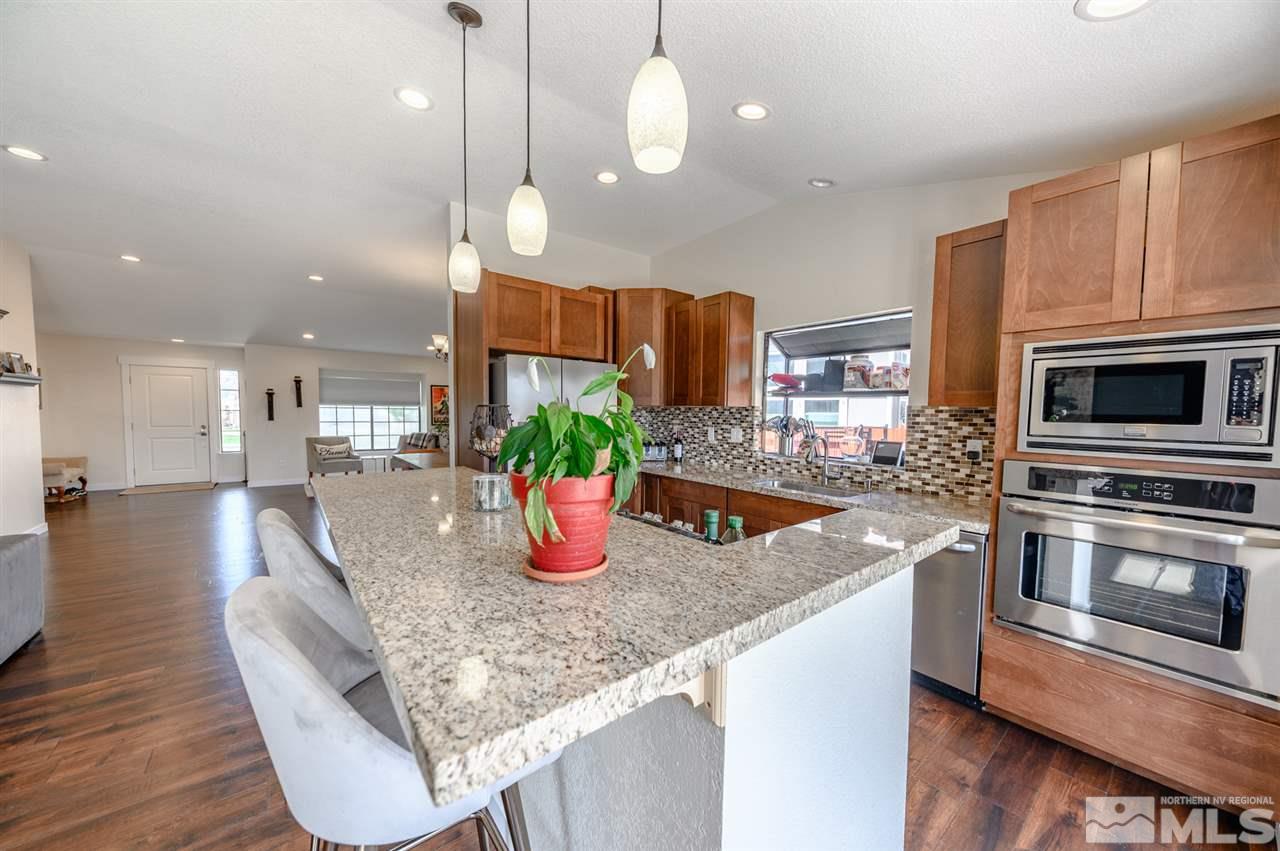 1844 Quail Run Road Reno, NV 89523 - Photo 7 of 15 a kitchen with stainless steel appliances granite countertop a sink a stove and a wooden floors