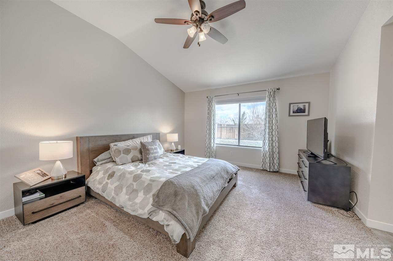 1844 Quail Run Road Reno, NV 89523 - Photo 8 of 15 a bedroom with a bed a chandelier and a flat tv screen on a dresser