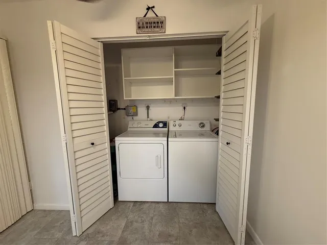 a utility room with cabinets and washer dryer