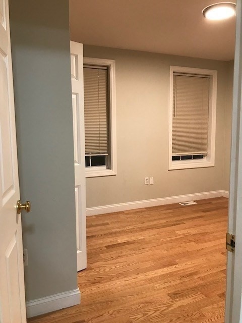 157-159 Fuller Street Boston, MA 02124 - Photo 11 of 19 a view of an empty room with wooden floor and a window